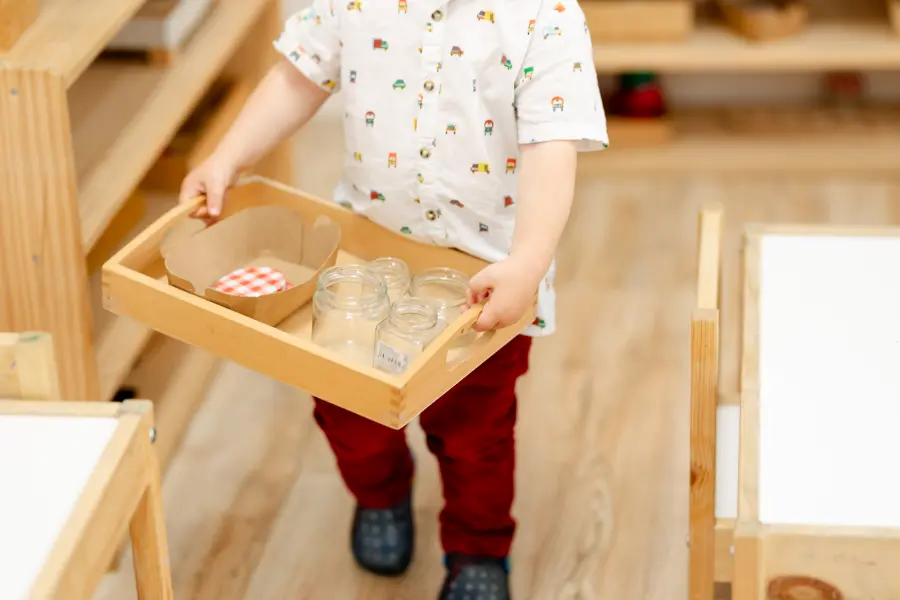 Niño en ambiente de comunidad infantil montessori, realizando una actividad que refina su movimiento, ganando seguridad física y una mayor conexión mente-cuerpo.
