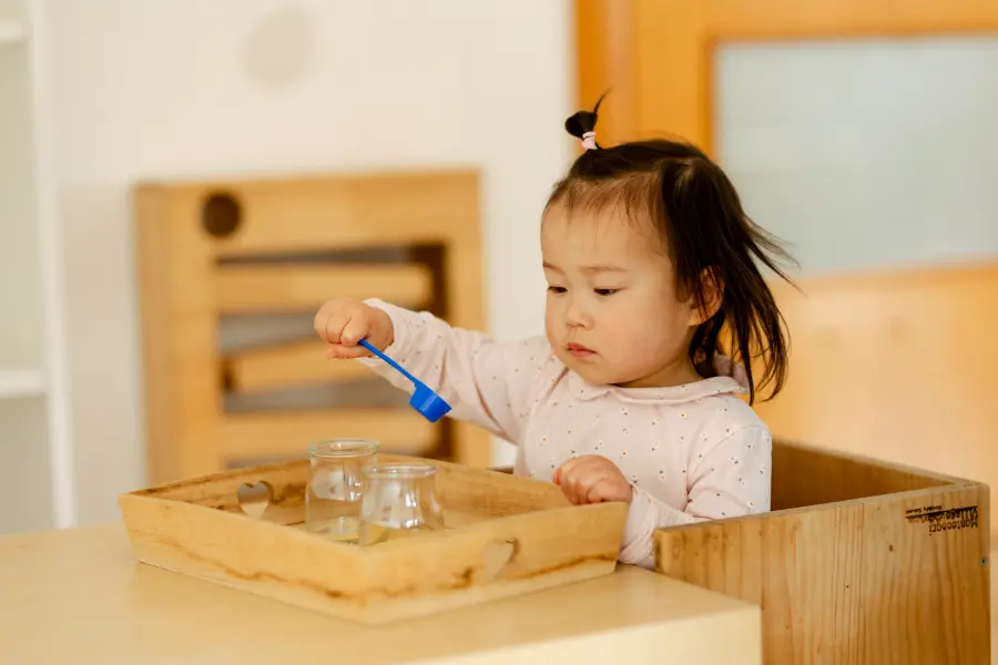 Niña en ambiente Nido Montessori concentrada en una actividad oculo-manual