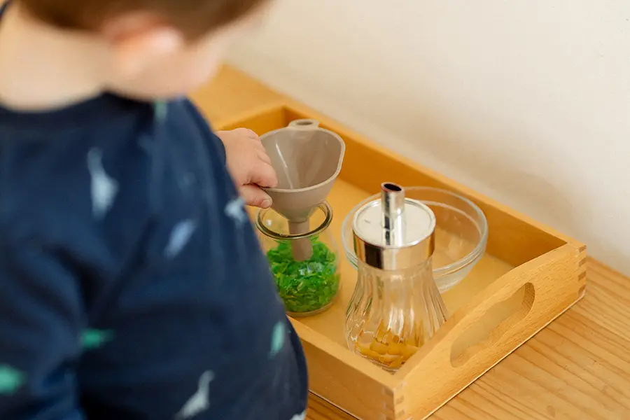 Niño en ambiente prepardo Montessori Nido explorando objetos reales